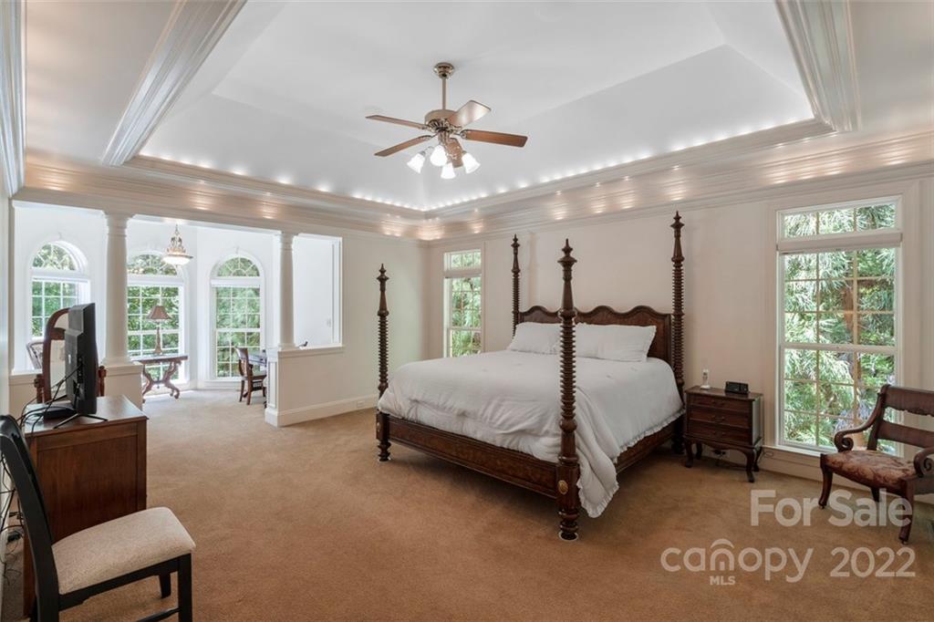 312 Devonport Drive Matthews, NC 28104 - Photo 24 of 48 a spacious bedroom with a bed couch and a large window