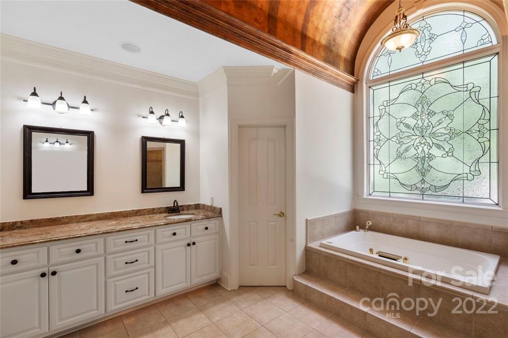 312 Devonport Drive Matthews, NC 28104 - Photo 29 of 48 a spacious bathroom with a granite countertop tub sink a mirror and shower