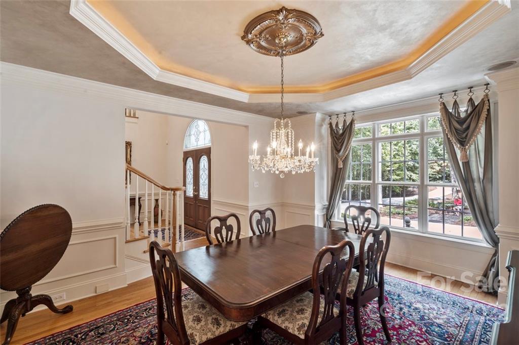 312 Devonport Drive Matthews, NC 28104 - Photo 5 of 48 a view of a dining room with furniture a chandelier and wooden floor