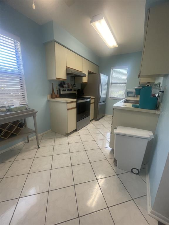 25068 Harbor View Road, Unit 3D Punta Gorda, FL 33980 - Photo 13 of 27 a kitchen with a sink a stove a microwave and cabinets