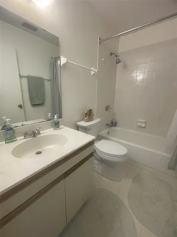 a bathroom with a double vanity sink toilet mirror and shower