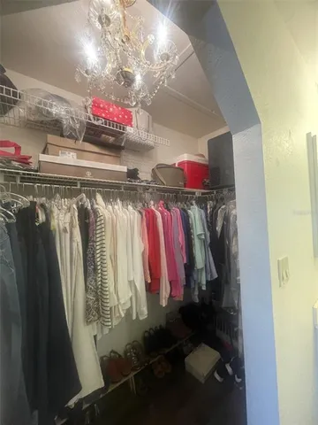 a view of walk in closet with clothes and shoes