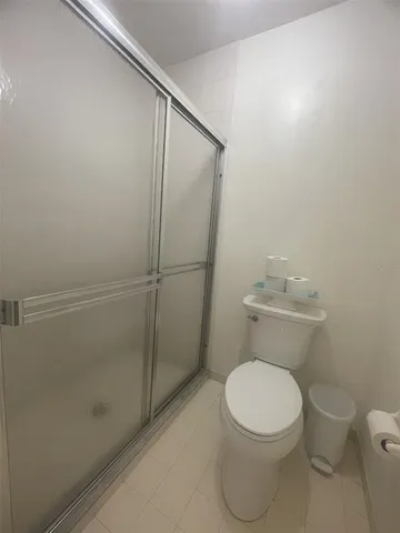 a white toilet sitting next to a shower