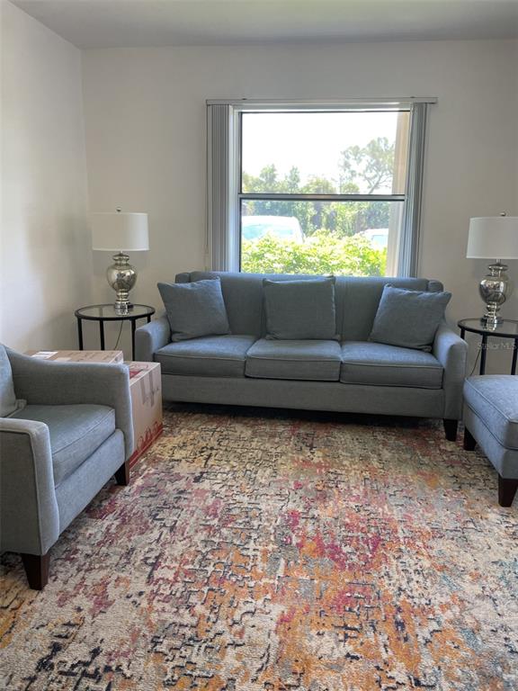 25068 Harbor View Road, Unit 3D Punta Gorda, FL 33980 - Photo 5 of 24 a living room with furniture and a large window