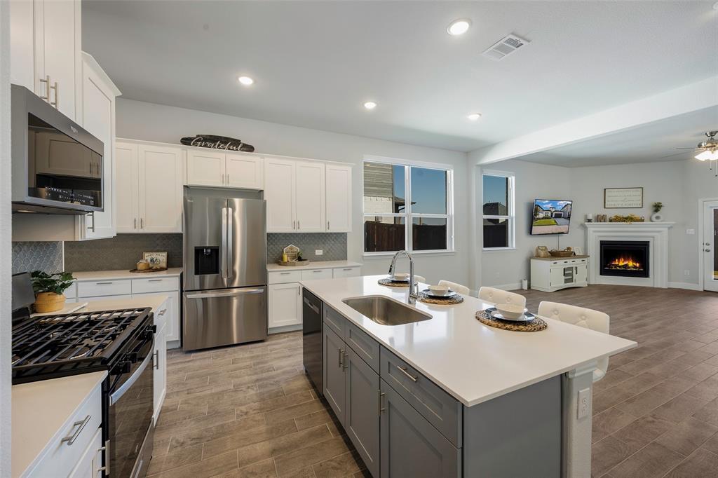 1617 Hitching Post Road Weston, TX 75009 - Photo 7 of 30 a kitchen with stainless steel appliances a sink stove and refrigerator