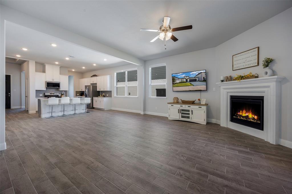 1617 Hitching Post Road Weston, TX 75009 - Photo 9 of 30 a view of a livingroom with furniture a fireplace window and wooden floor