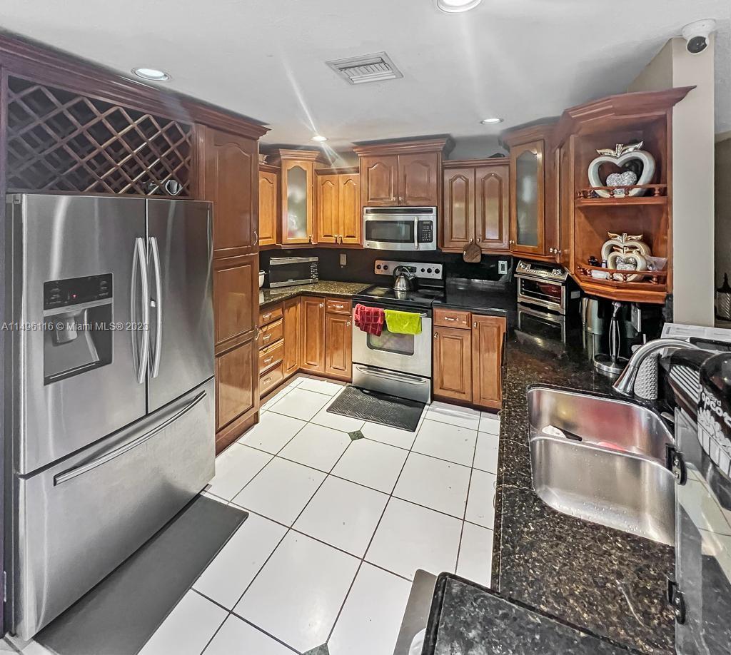 The Hammocks Miami, FL 33196 - Photo 6 of 20 a kitchen with stainless steel appliances granite countertop a refrigerator and a stove top oven