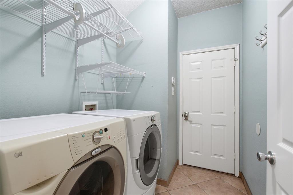 4218 Glistening Spring Rowlett, TX 75088 - Photo 32 of 39 Dedicated laundry area featuring white wire shelving, light blue walls, and durable tile flooring