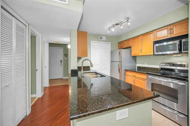 a kitchen with stainless steel appliances granite countertop a sink stove and microwave