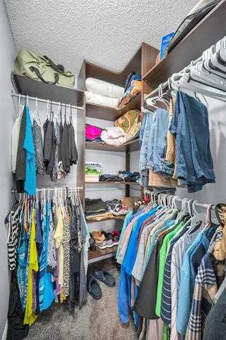 a view of walk in closet with clothes and shoes
