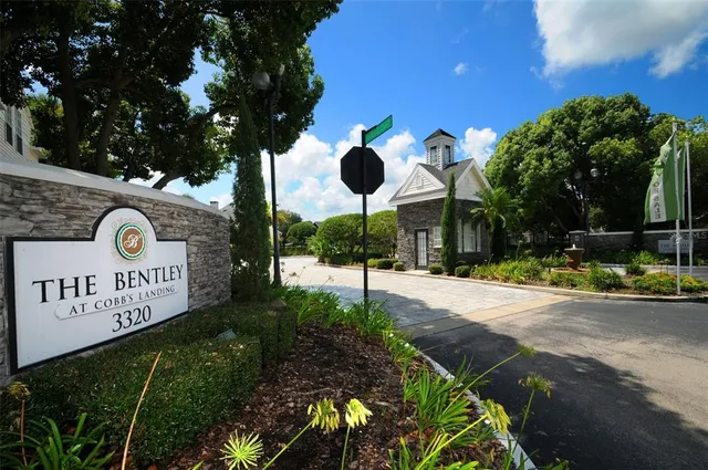 a view of a park that has a sign board large trees