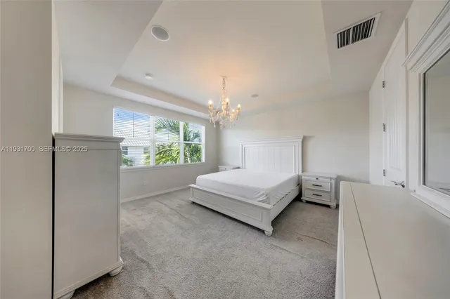 a spacious bedroom with a bed and a dresser