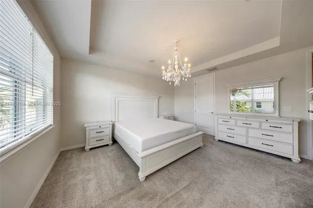 a bedroom with a large bed and a chandelier