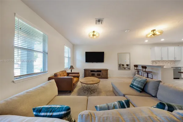 a living room with furniture and a dining table with projector