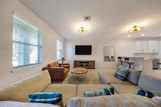 a living room with furniture and a dining table with projector