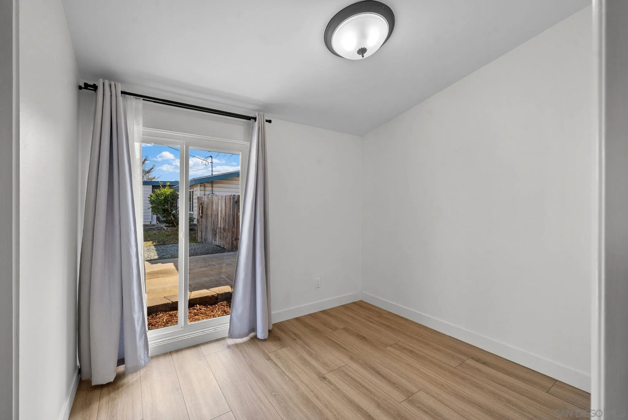 9101 Ronda Avenue San Diego, CA 92123 - Photo 8 of 20 an empty room with wooden floor and windows