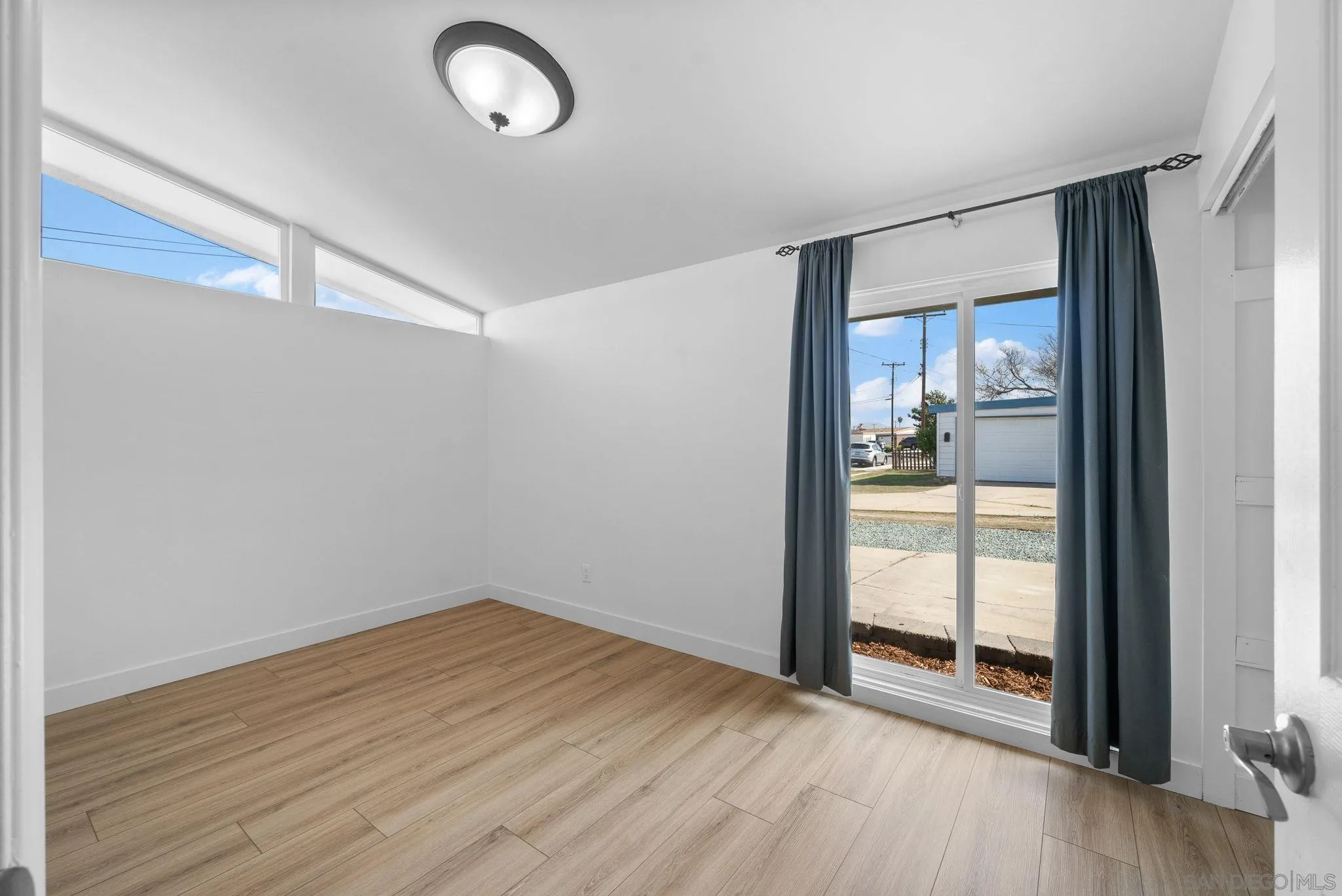 9101 Ronda Avenue San Diego, CA 92123 - Photo 10 of 20 a view of an empty room with wooden floor and a window