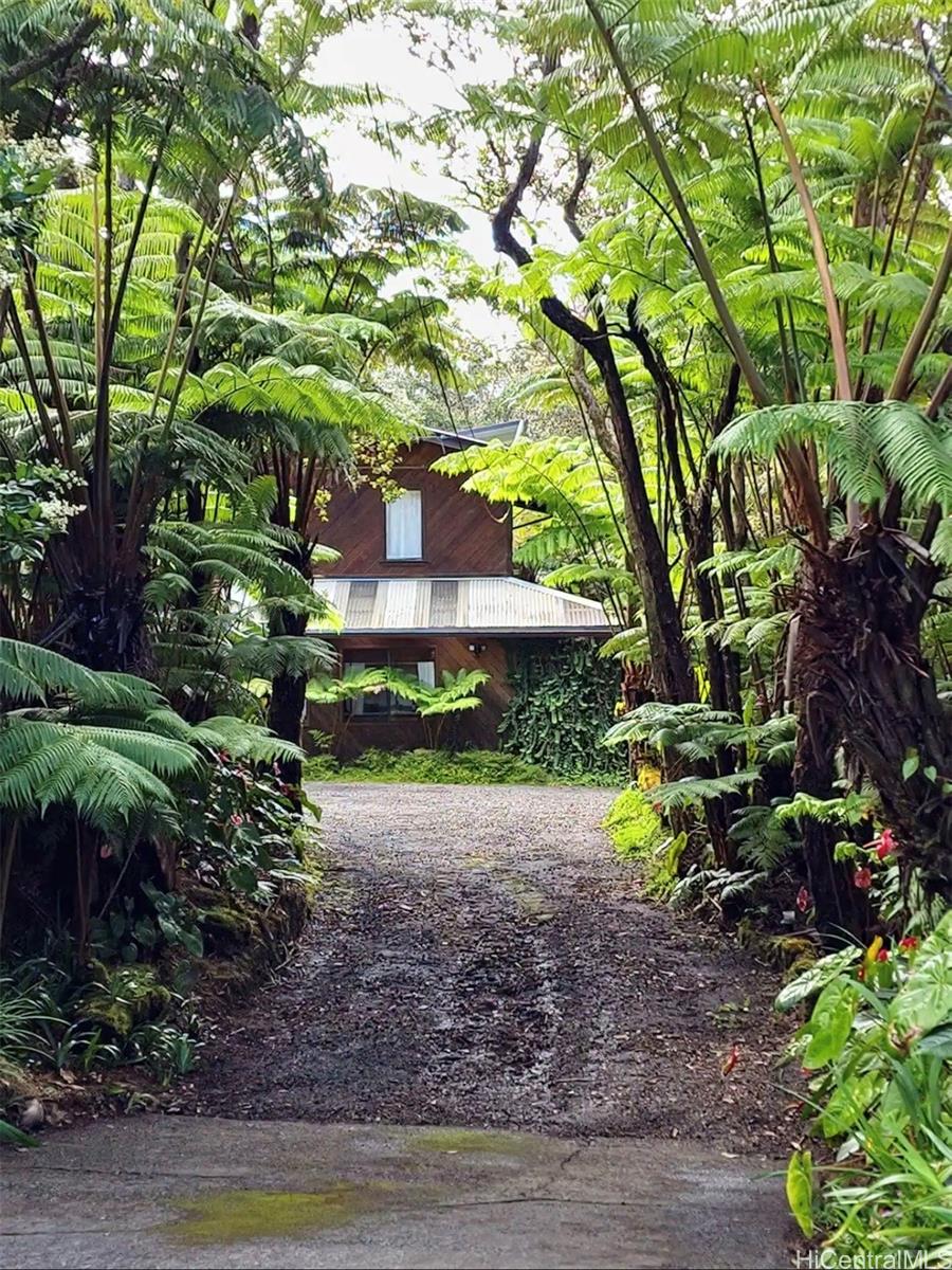 a backyard of a house with a garden and outdoor seating