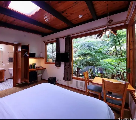 a bedroom with furniture and large windows