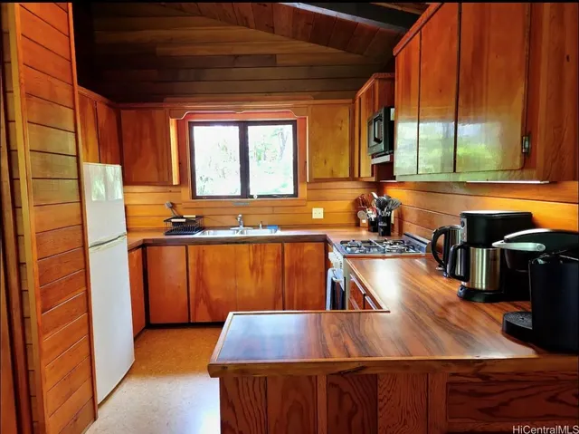a view of a kitchen with kitchen island a large window appliances and cabinets