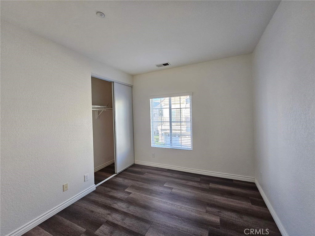 7331 Shelby Place, Unit 121 Rancho Cucamonga, CA 91739 - Photo 12 of 20 an empty room with wooden floor and windows