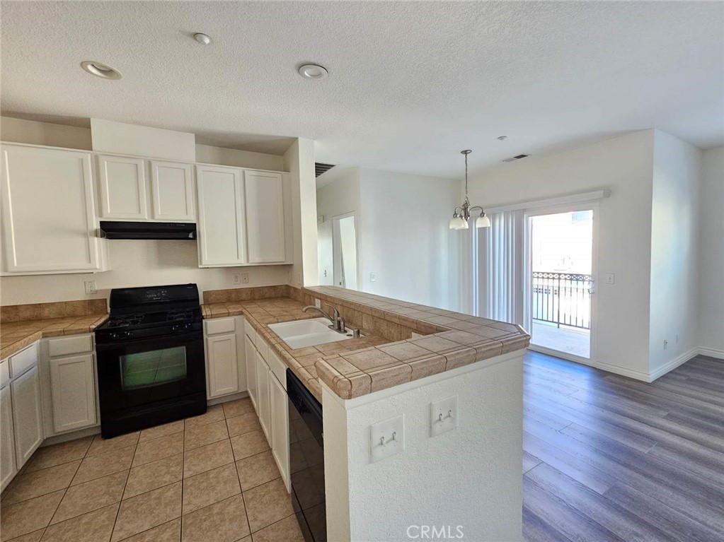 7331 Shelby Place, Unit 121 Rancho Cucamonga, CA 91739 - Photo 9 of 20 a kitchen with a stove sink and cabinets