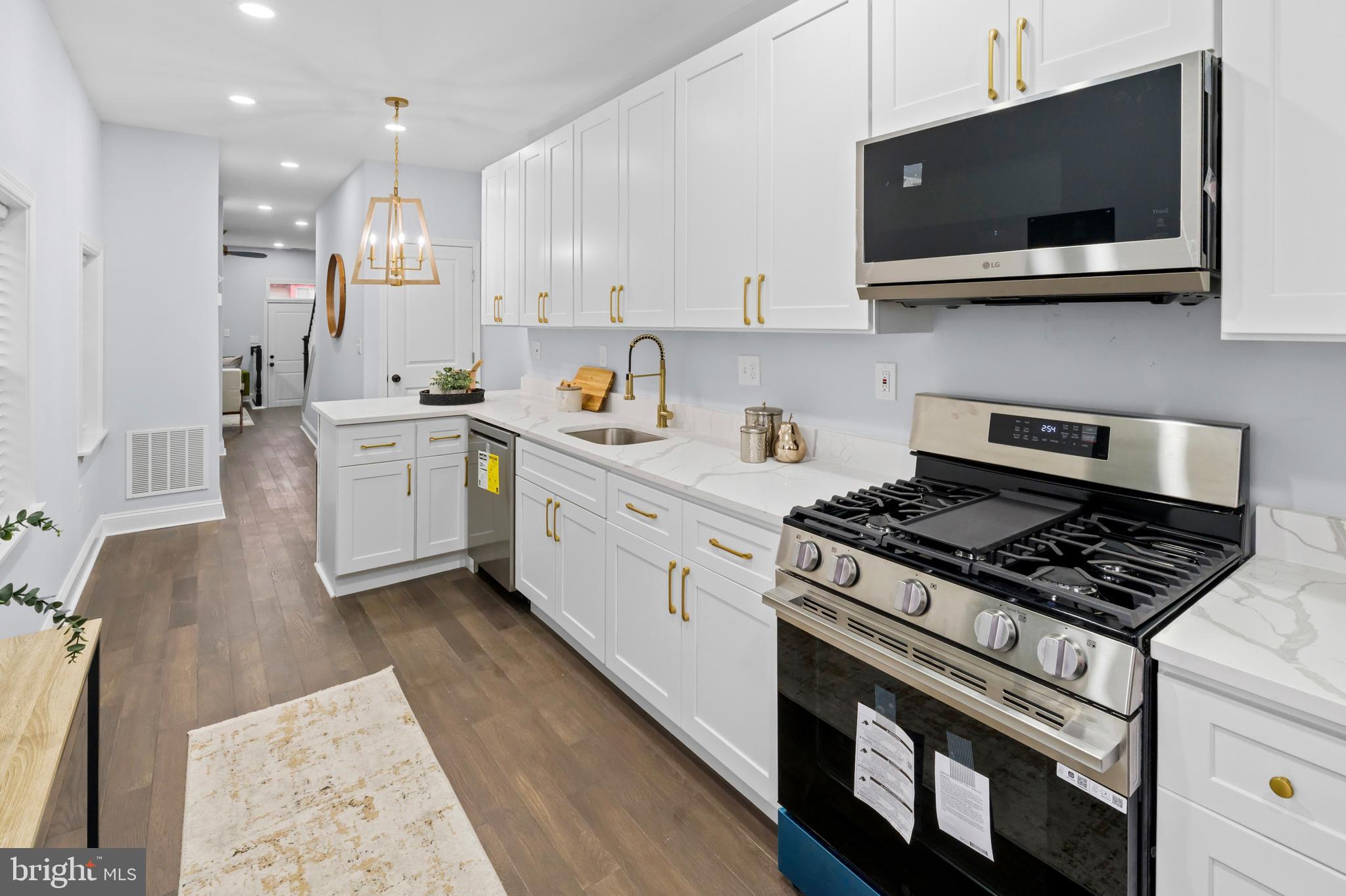 1612 East Chase Street Baltimore, MD 21213 - Photo 13 of 48 a kitchen with stainless steel appliances white cabinets and sink