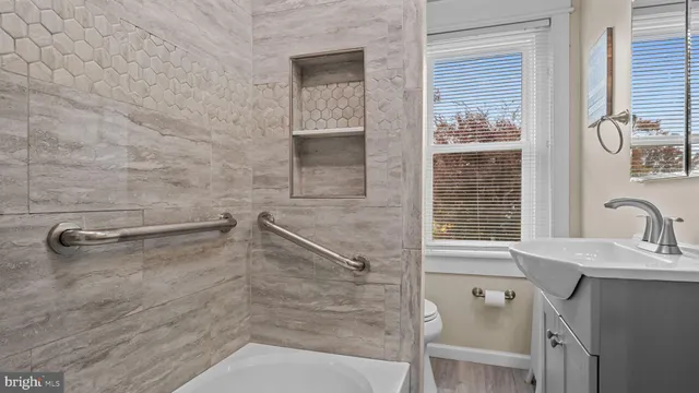 a bathroom with a sink a window and shower