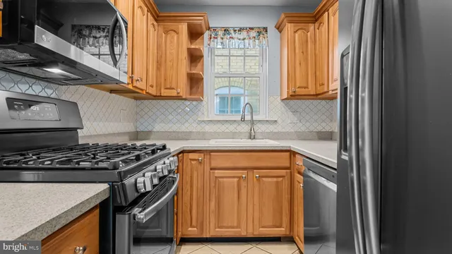 a kitchen with stainless steel appliances granite countertop a sink stove and cabinets