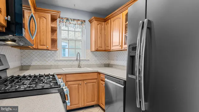a kitchen with stainless steel appliances granite countertop a refrigerator and a stove
