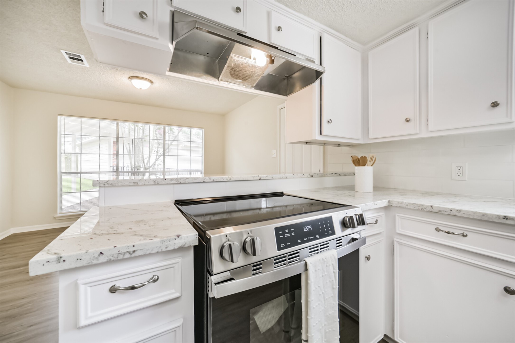 1011 Baltic Lane Houston, TX 77090 - Photo 13 of 43 a kitchen with granite countertop white cabinets and white appliances