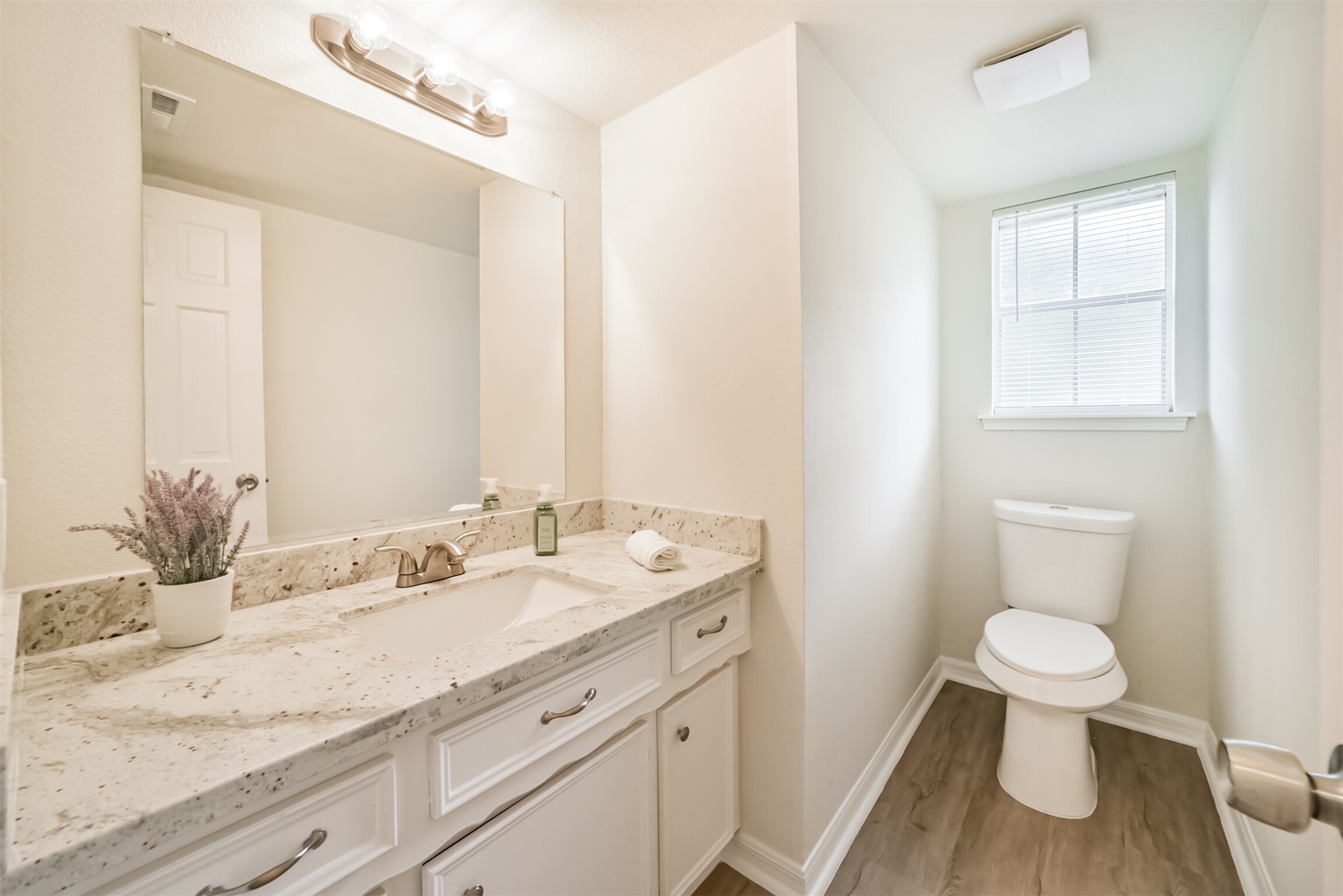 1011 Baltic Lane Houston, TX 77090 - Photo 30 of 43 a bathroom with a granite countertop sink a toilet and a mirror