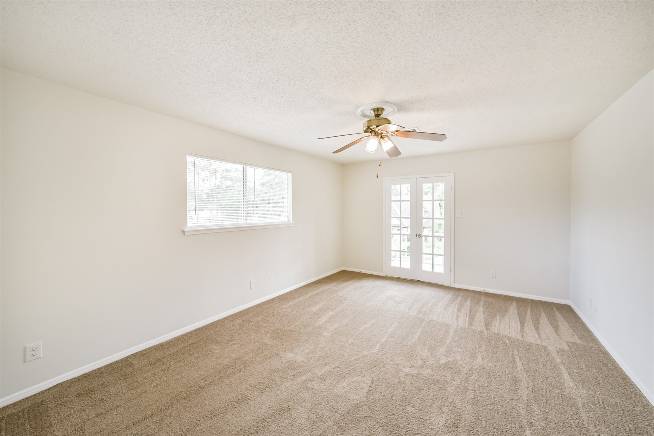 1011 Baltic Lane Houston, TX 77090 - Photo 33 of 43 an empty room with windows and chandelier fan