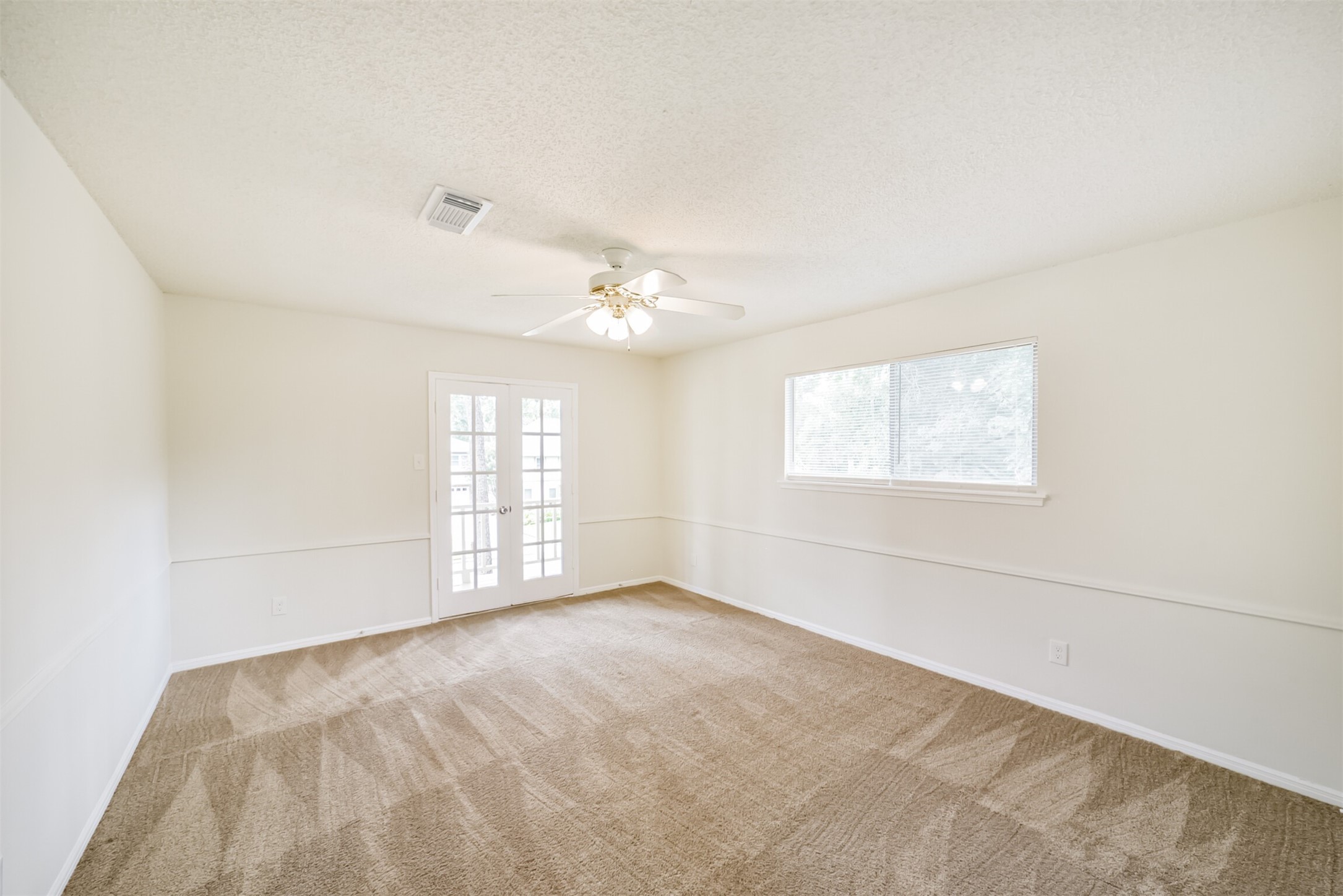 1011 Baltic Lane Houston, TX 77090 - Photo 38 of 43 an empty room with windows and chandelier fan