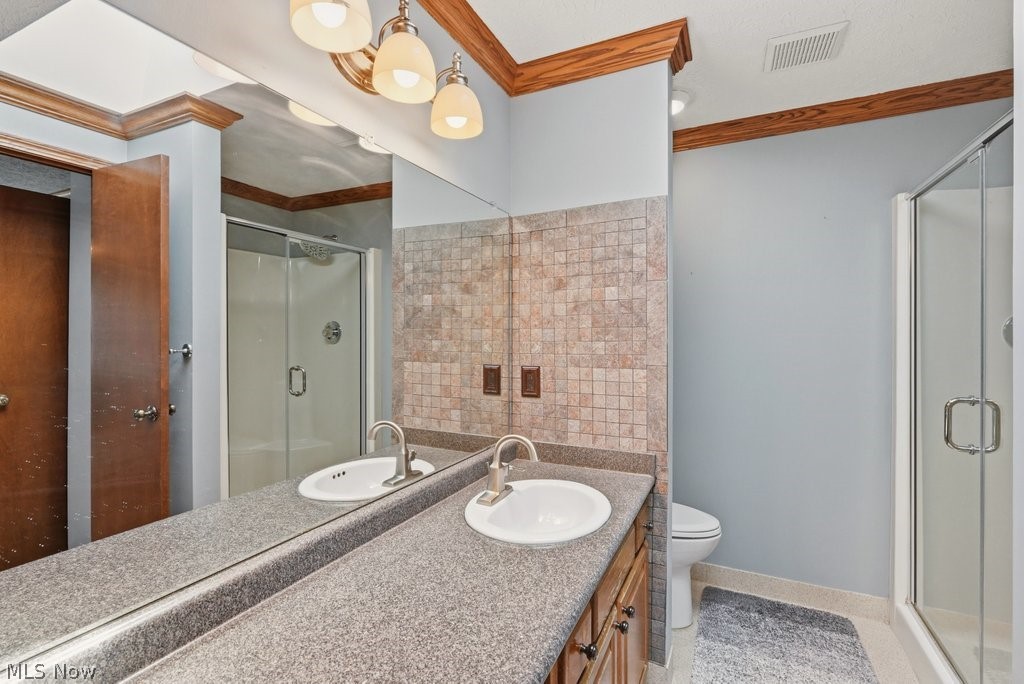 5321 Young Road Stow, OH 44224 - Photo 24 of 37 Vanity with dual sinks and a speckled countertop, a tiled backsplash, and a glass-enclosed shower