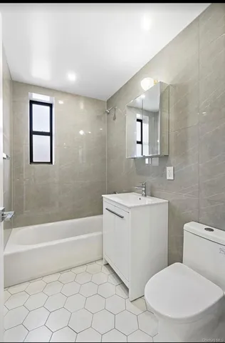 a bathroom with a toilet a sink a mirror and bathtub