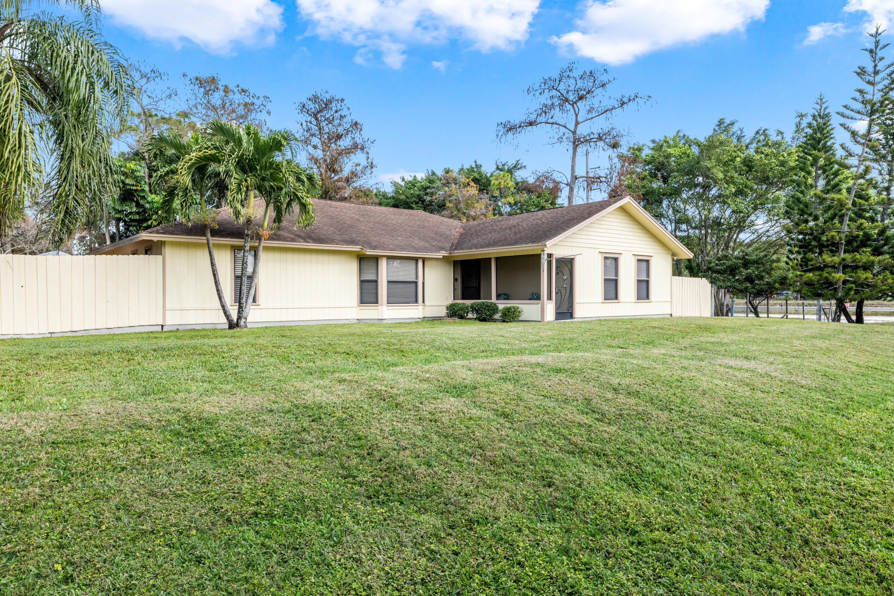 16887 West Cornwall Drive Loxahatchee, FL 33470 - Photo 1 of 37 a front view of a house with a yard