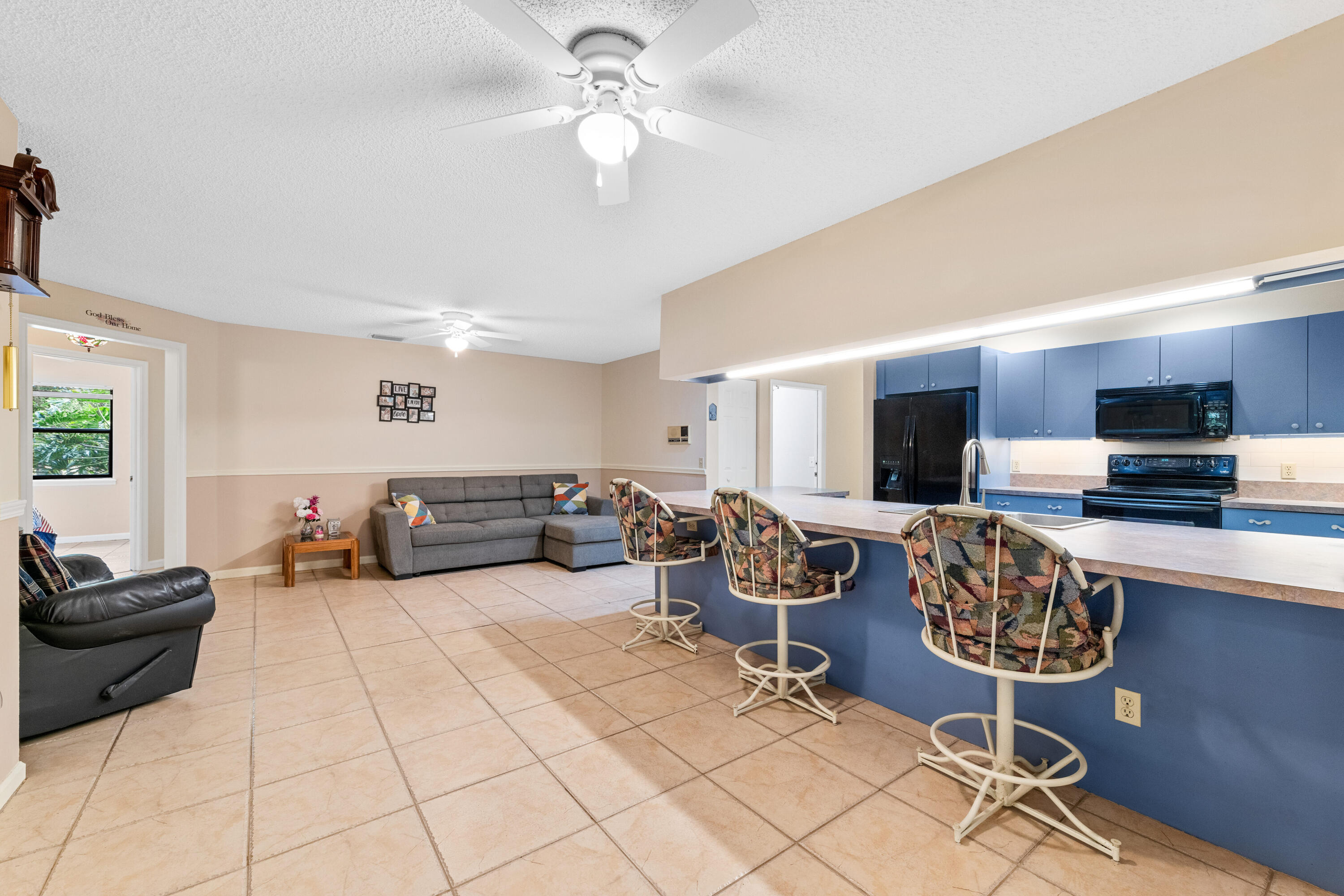 16887 West Cornwall Drive Loxahatchee, FL 33470 - Photo 3 of 37 a living room with furniture a chandelier and a flat screen tv
