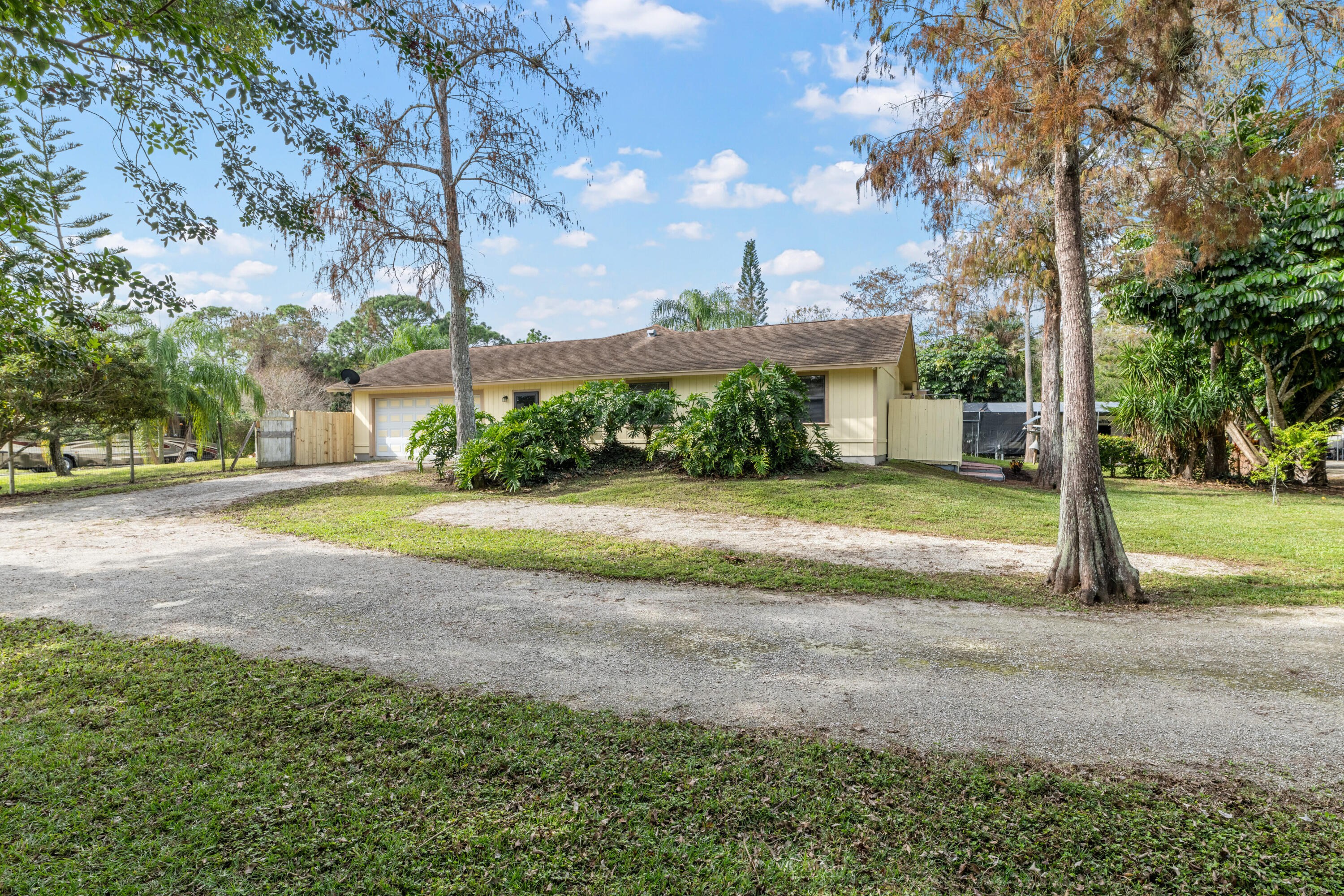 16887 West Cornwall Drive Loxahatchee, FL 33470 - Photo 34 of 37 a view of a house with backyard and trees