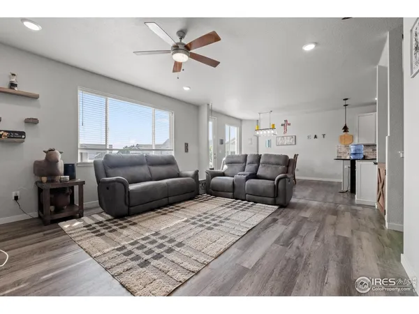 a living room with furniture and a ceiling fan