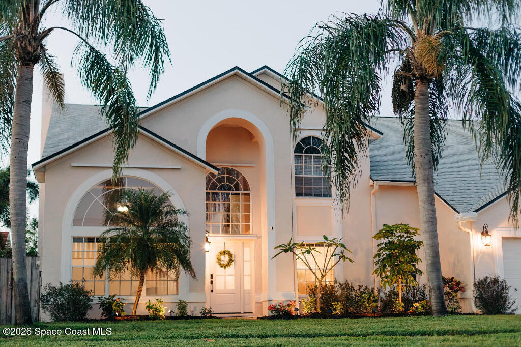 a front view of multi story residential apartment building with yard and green space