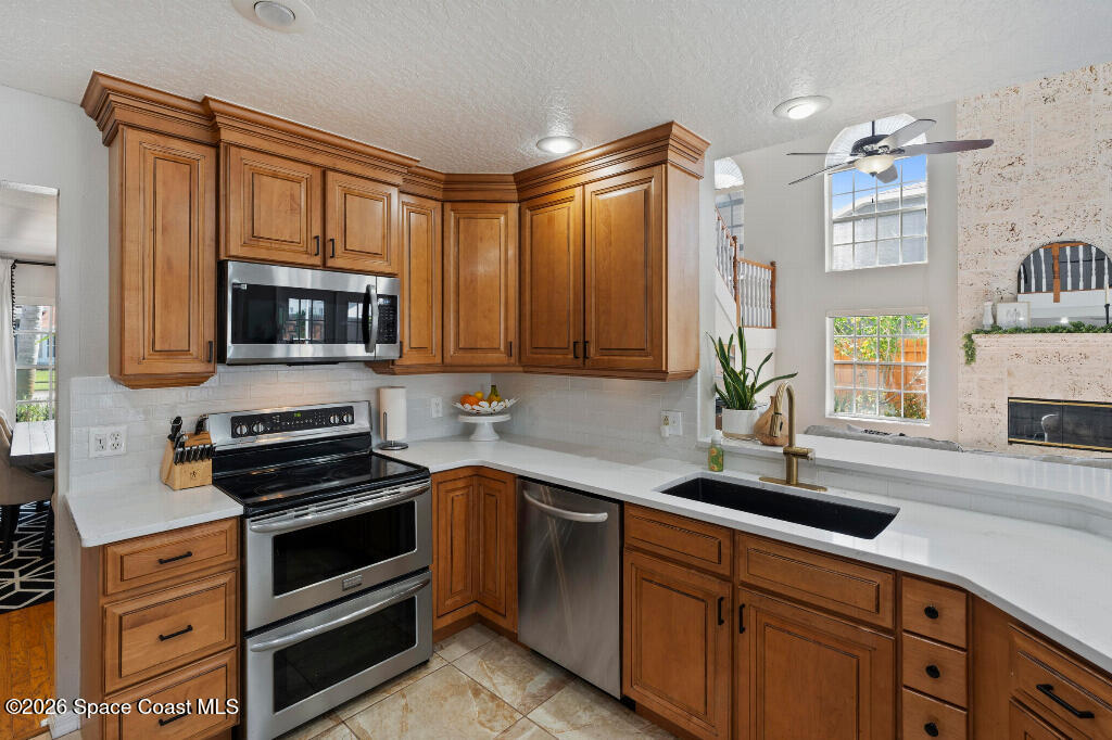 2639 Lowell Circle Melbourne, FL 32935 - Photo 17 of 45 a kitchen with stainless steel appliances a stove sink and cabinets