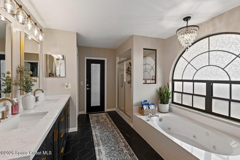 2639 Lowell Circle Melbourne, FL 32935 - Photo 22 of 45 a bathroom with a granite countertop tub a sink and a large mirror