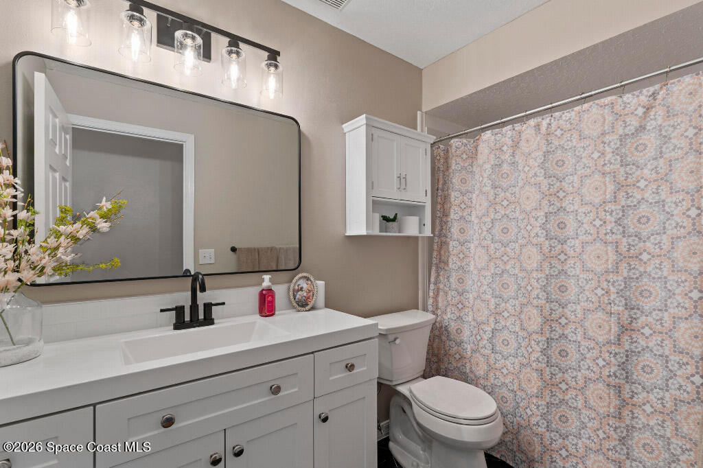 2639 Lowell Circle Melbourne, FL 32935 - Photo 31 of 45 a bathroom with a sink a toilet and a mirror