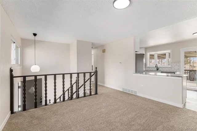 a view of a hallway with kitchen and dining area