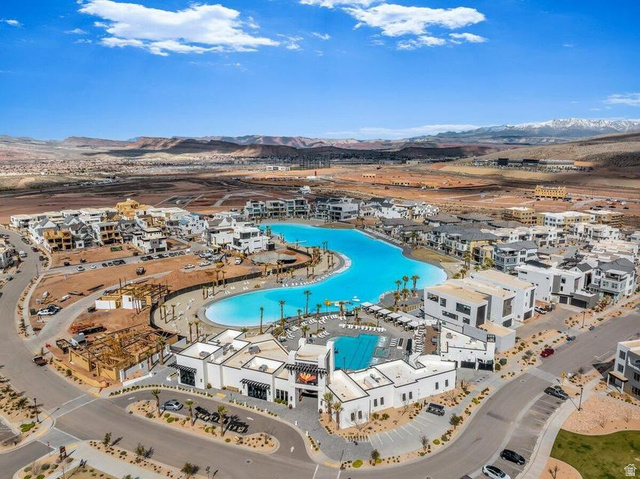 5898 Jasper Rdg Drive St. George, UT 84790 - Photo 29 of 41 Aerial view of a sprawling resort-style community featuring a striking lagoon-form swimming pool as the centerpiece, surrounded by whitewashed residential architecture with terracotta-toned roofing