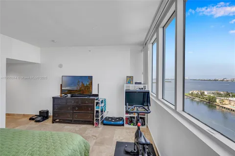 a living room with furniture book shelf and a large window