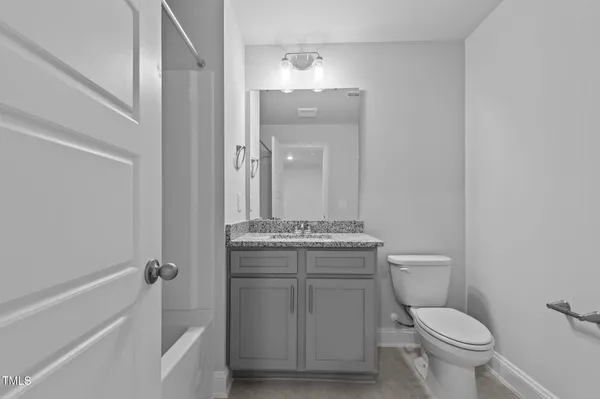 a bathroom with a granite countertop toilet a sink and bathtub