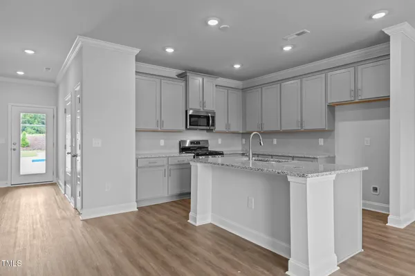 a kitchen with a sink a microwave a refrigerator and cabinets