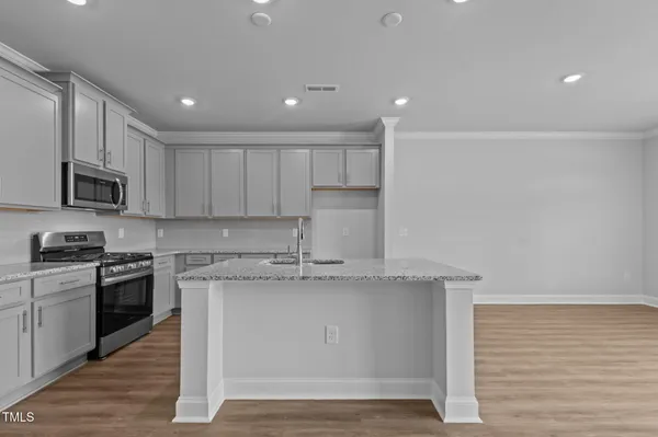 a kitchen with stainless steel appliances granite countertop a stove a sink and a microwave